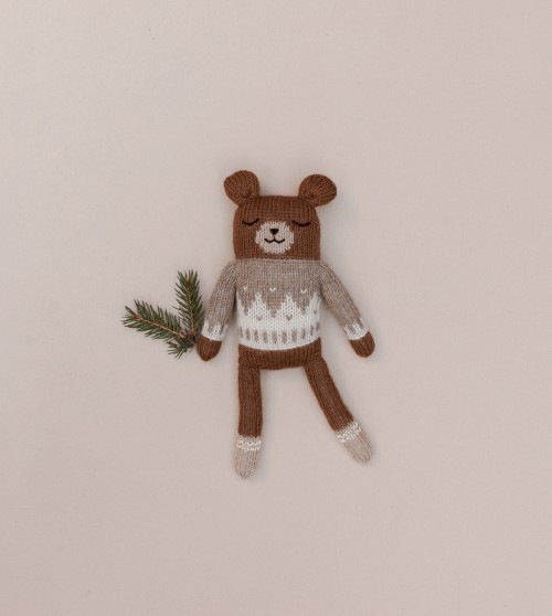 Doudou Ourson en tricot marron avec motif blanc, tenant une branche de sapin.
