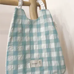 Serviette Élastique Vichy Lagon avec motif à carreaux bleus et blancs, accrochée.